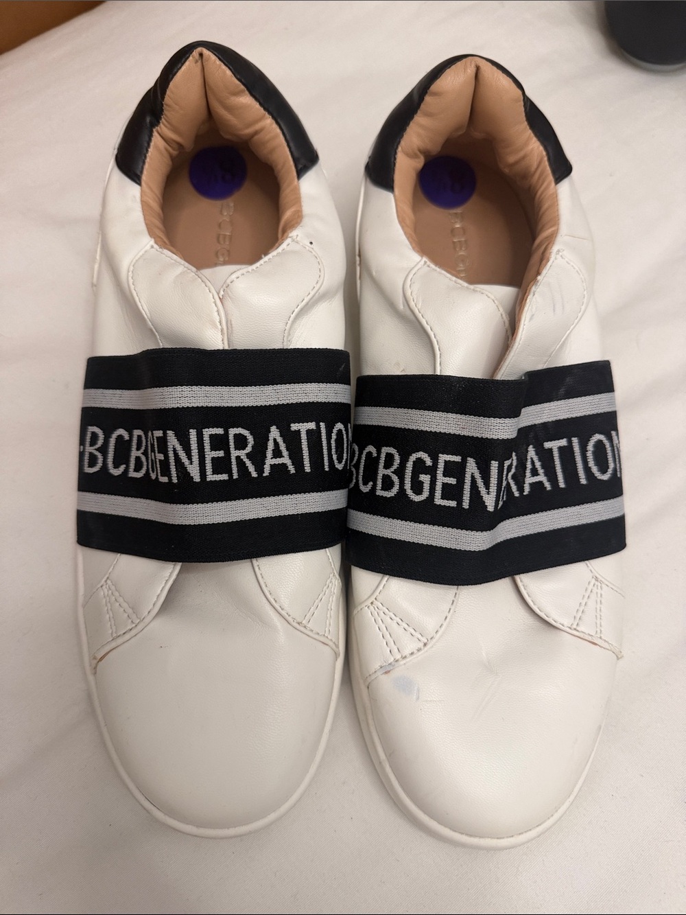 BCBGeneration Womens White Slip-On Sneakers with Black Logo Band